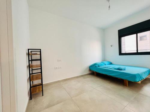 Or YehudaLuxury Penthouse 5 Rooms的小房间设有蓝色的床和梯子