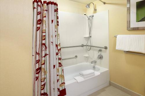 纽瓦克纽瓦克格兰维尔万怡酒店的浴室配有白色的浴缸和淋浴帘