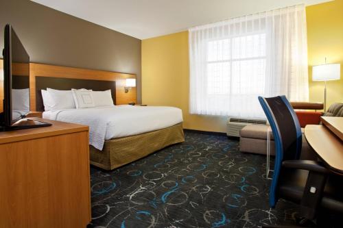 卡尔斯巴德TownePlace Suites by Marriott Carlsbad的酒店客房,配有床和电视