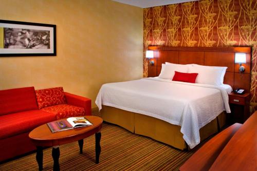 劳雷尔山劳雷尔山万怡酒店的酒店客房,配有一张床和一张红色的沙发