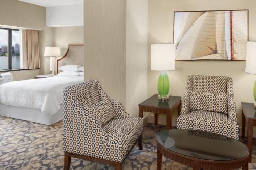 威霍肯林肯港喜来登酒店的配有床、椅子和桌子的酒店客房