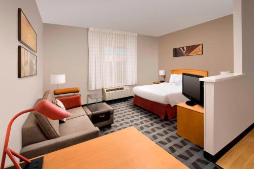 阿尔伯克基TownePlace Suites by Marriott Albuquerque Airport的酒店客房,配有床和沙发