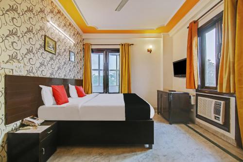 古尔冈Super Capital O Tipsyy 006 Near Aravali Biodiversity Park的一间酒店客房,配有一张床和一台电视