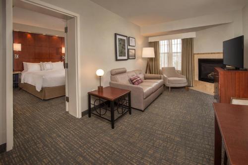斯特灵杜勒斯机场达拉斯28中心原住客栈的酒店客房设有床和客厅。