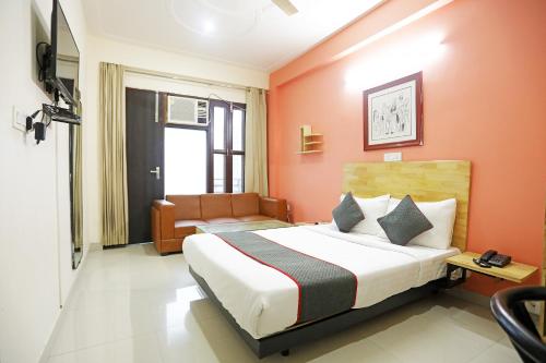 古尔冈Townhouse Cloud Bay, Near Genpact, Sector-69, Gurgaon的一间卧室配有一张带橙色墙壁的床和一张沙发