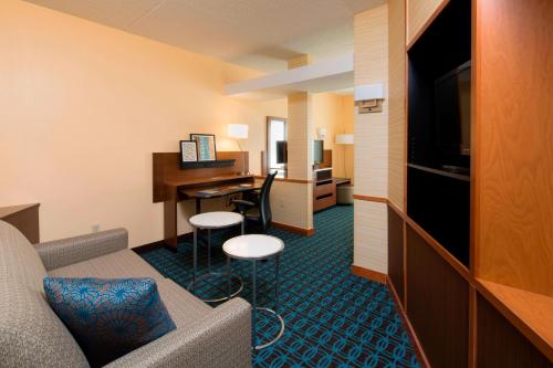 纽瓦克纽瓦克自由国际机场万豪费尔菲尔德套房酒店的酒店客房设有沙发、书桌和电脑