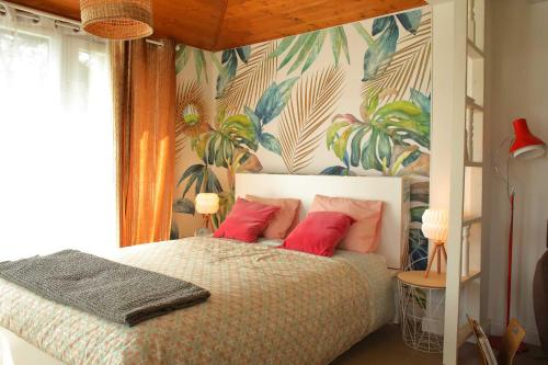 ČtyřkolyApartmán Marmeláda的一间卧室配有一张带红色枕头的床和热带壁纸
