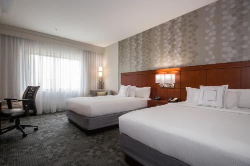康科德康科德夏洛特万怡酒店的酒店客房,配有两张床和椅子