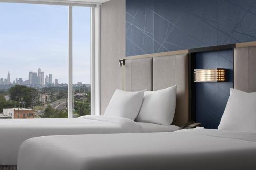 卡尔施塔特SpringHill Suites by Marriott East Rutherford Meadowlands Carlstadt的配有大窗户的酒店客房内的两张床
