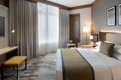 科威特Marriott Executive Apartments Kuwait City的一间设有大床和窗户的酒店客房