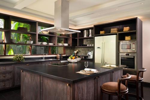 乌布Mandapa, a Ritz-Carlton Reserve的厨房配有黑色台面和冰箱