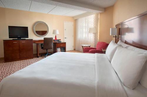 尤宁戴尔长岛万豪酒店的酒店客房设有一张白色大床和一张书桌