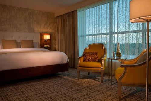 巴吞鲁日巴顿鲁日万丽酒店的酒店的客房 - 带一张床、椅子和窗户