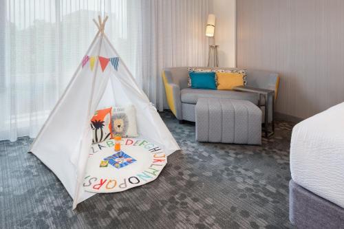 阿尔法利塔Courtyard by Marriott Atlanta Alpharetta/Avalon Area的一间设有一张床和一个游戏帐篷的房间