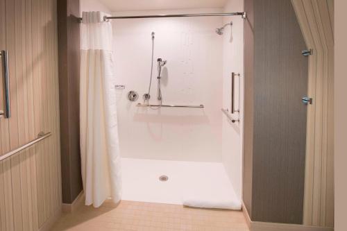 阿尔法利塔Courtyard by Marriott Atlanta Alpharetta/Avalon Area的设有带白色浴缸的淋浴的浴室