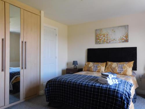 福尔柯克Double room with ensuite, tea & coffee, Falkirk, Scotland的一间卧室配有一张带蓝色铺面毯子的床