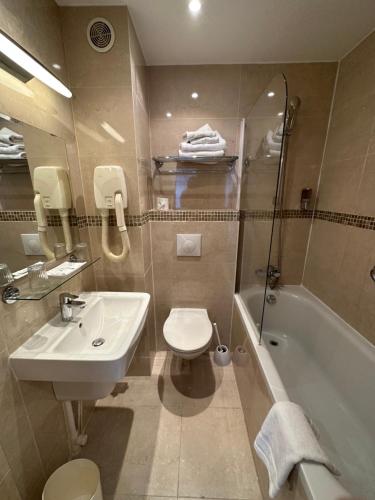 巴黎阿根诺酒店的浴室配有盥洗盆、卫生间和浴缸。