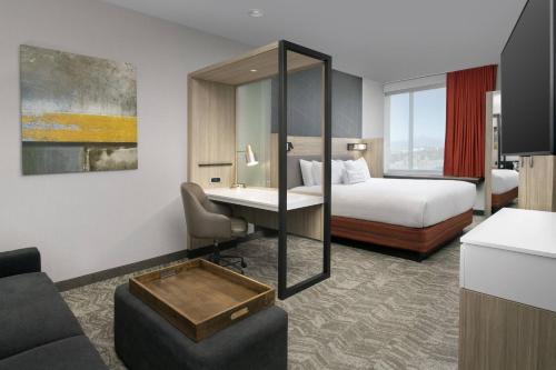 温莎SpringHill Suites by Marriott Loveland Fort Collins/Windsor的配有一张床和一张书桌的酒店客房