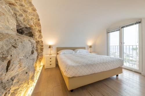 卡普里Casa Boutique by Capri 5 Senses的一间卧室设有一张床和一个大石墙