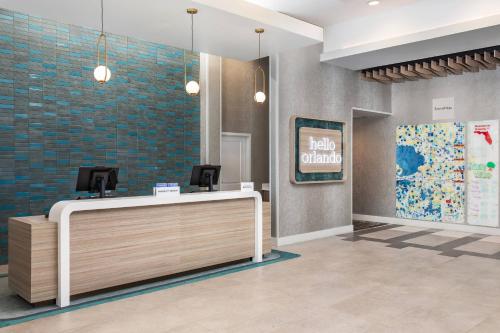奥兰多TownePlace Suites By Marriott Orlando Southwest Near Universal的大堂设有前台和Hello普通标志