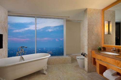 棉兰棉兰JW万豪酒店的带浴缸的浴室和大窗户