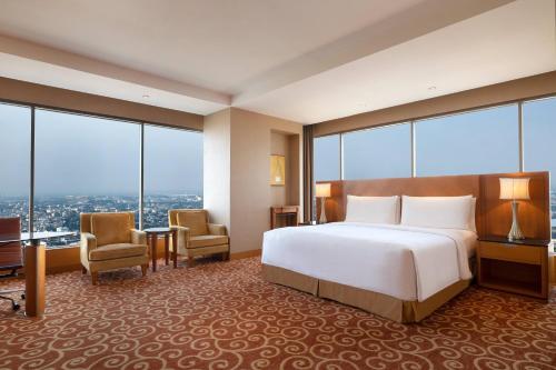 棉兰棉兰JW万豪酒店的酒店客房设有一张床和大窗户