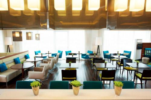 戴斯阿伯丁机场万怡酒店的一间带桌椅和蓝色椅子的餐厅