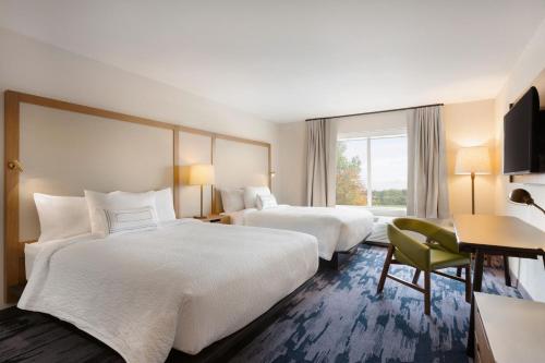 朗蒙特Fairfield Inn & Suites by Marriott Boulder Longmont的酒店客房配有两张床和一张书桌