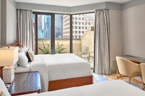 温哥华温哥华大都会饭店的酒店客房设有两张床和大窗户。