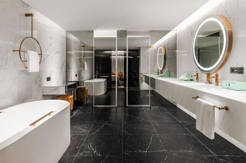 台中市台中李方艾美酒店的浴室设有2个水槽、浴缸和镜子