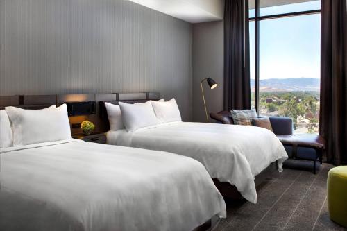 里诺Renaissance Reno Downtown Hotel & Spa的酒店客房设有两张床和窗户。