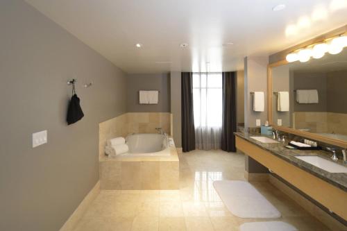 里诺Renaissance Reno Downtown Hotel & Spa的浴室配有两个盥洗盆和浴缸。