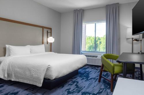 落基山Fairfield Inn & Suites Rocky Mount的酒店客房配有一张床、一张桌子和一把椅子。