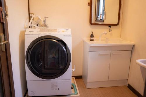 诹访市一組貸切宿 岡村 弐番館 一棟まるまる貸切的盥洗盆旁浴室内的洗衣机