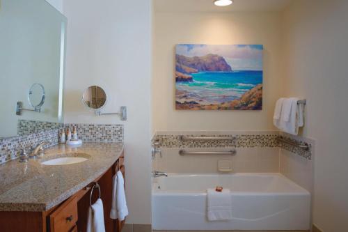 科洛阿威尔亥海滩俱乐部万豪酒店的带浴缸的浴室和墙上的绘画