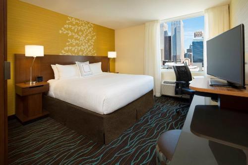 卡尔加里Fairfield Inn & Suites by Marriott Calgary Downtown的酒店客房配有一张床、一张书桌和一台电视。