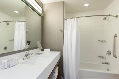 凯蒂休斯顿凯蒂米尔斯万怡酒店的浴室配有白色水槽和淋浴。
