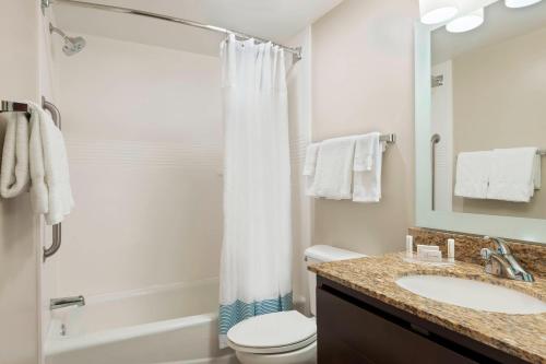 萨凡纳萨凡纳城中区广场套房酒店的一间带水槽、卫生间和淋浴的浴室