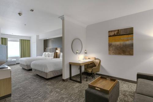 萨克拉门托SpringHill Suites by Marriott Sacramento Natomas的酒店客房设有两张床、一张桌子和一面镜子