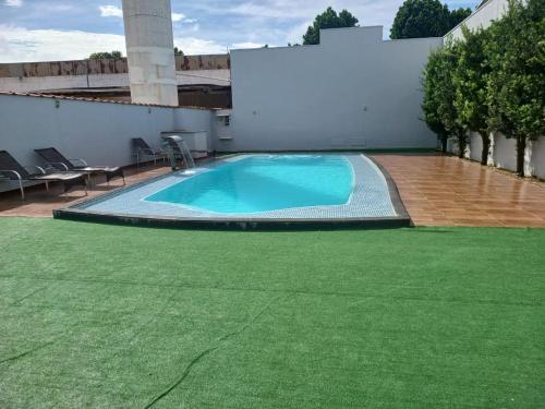 维列纳Hotel e Locadora Vizon的一座带绿色草坪的建筑中的大型游泳池