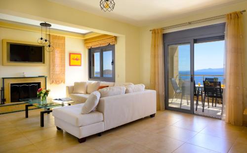 伊罗达Elounda Blue Waves Residence的客厅配有白色沙发和壁炉