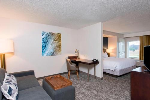 米德兰米德兰春季山丘套房酒店的酒店客房设有沙发、书桌和床。