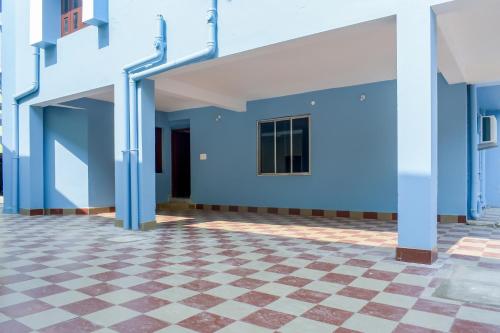 KhandagiriOYO Home Elite Stay Near Shri Shri Shiridi Sai Mandir的拥有蓝色墙壁和 ⁇ 格地板的建筑