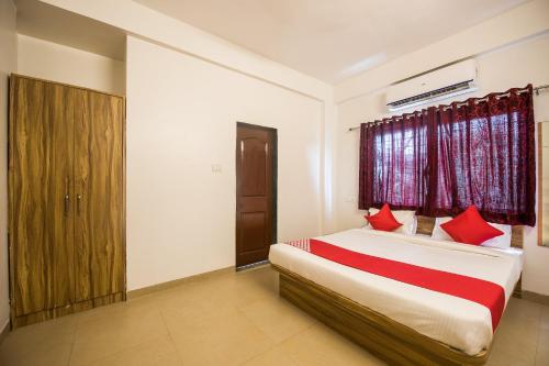 KharadiOYO Primrose Regency Near Amanora Mall的一间卧室配有红色枕头的床