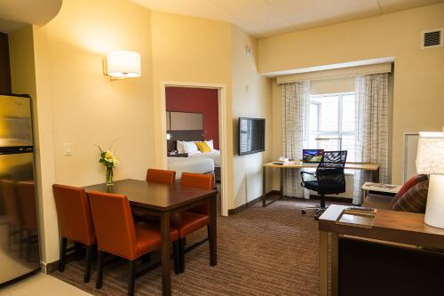渥太华万豪渥太华机场原住客栈的酒店客房设有一张桌子和一间卧室。