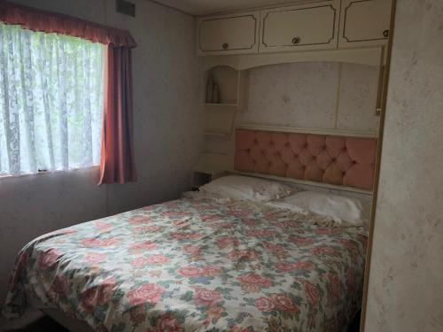奥古斯图Domek holenderski w Sajenku (Augustów)的一间卧室配有一张带花卉床罩的大床