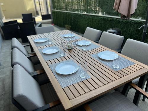 布尔加斯Hilton Burgas Holiday Home的一张木桌,上面放有盘子和酒杯