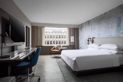 阿林顿水晶城万豪酒店里根国家机场店的酒店客房配有一张床、一张书桌和一台电视。