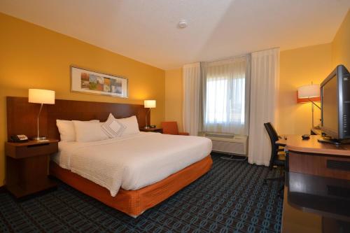 斯普林菲尔德Spark by Hilton Springfield Southwest的酒店客房配有一张床、一张书桌和一台电视。