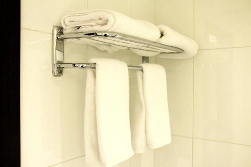 利雅德Business Inn Olaya的浴室提供毛巾架上的白色毛巾